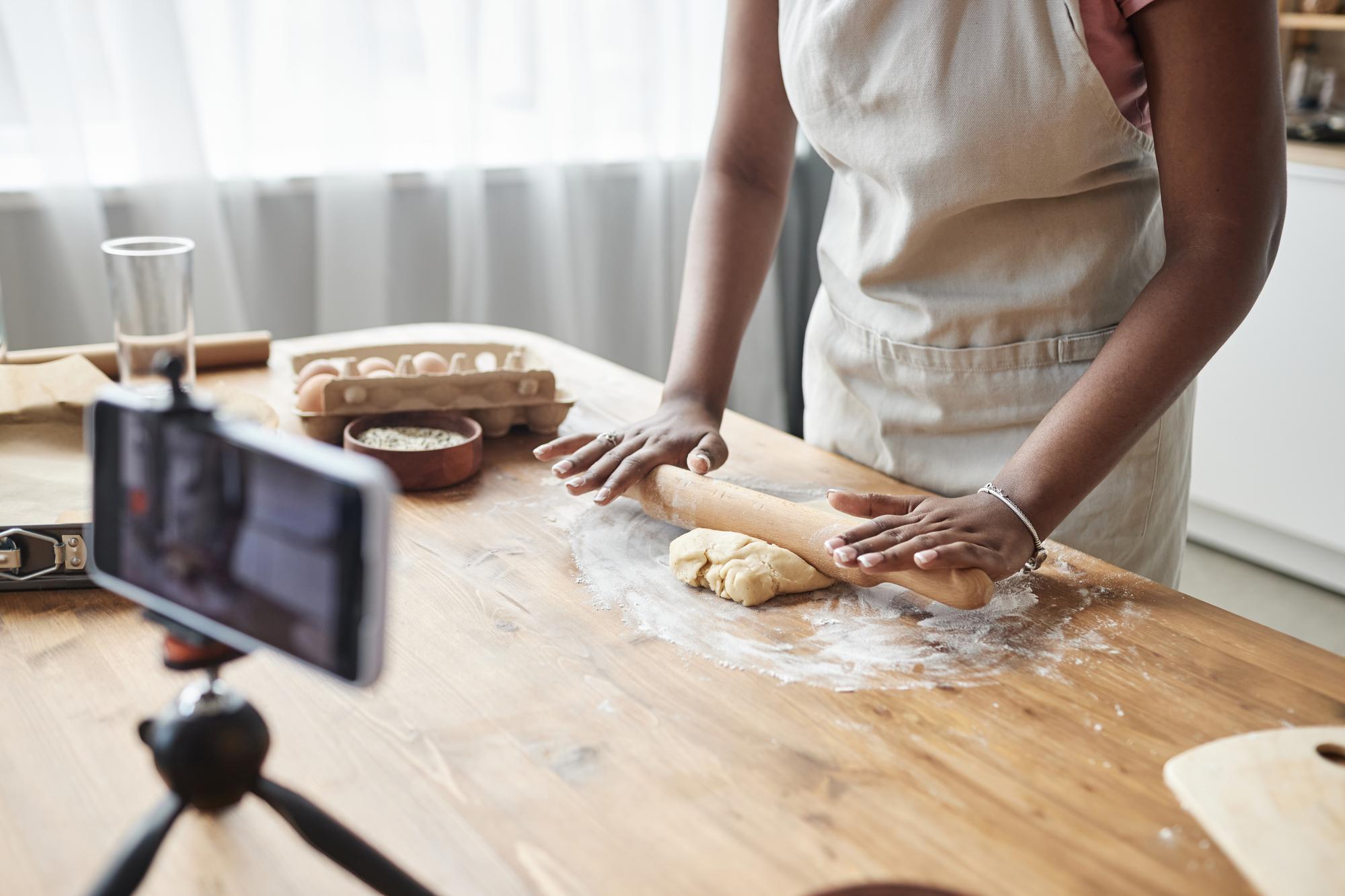 Close-up of hands kneading dough on a floured board